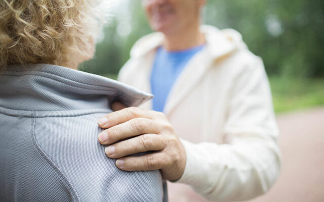 Hand on shoulder, discussing shoulder care