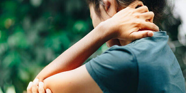 A person holding their elbow like they need to go see a elbow care specialists