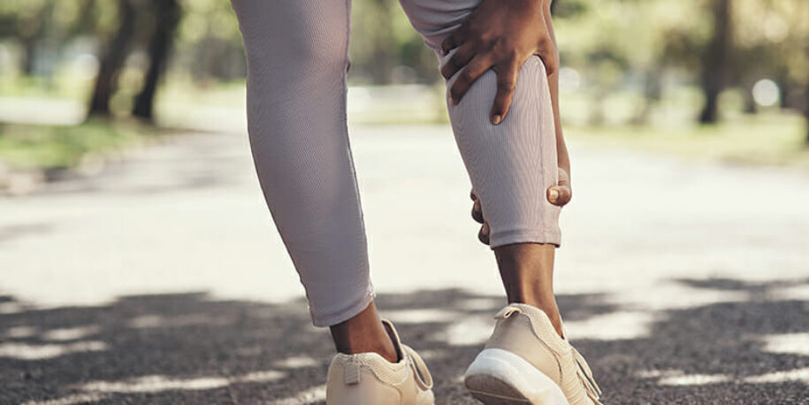 Women reaching for her calf, maybe a charley horse?