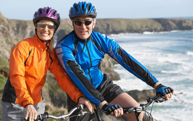 A Female and male biker on the coast representing if sports medicine is right for you.