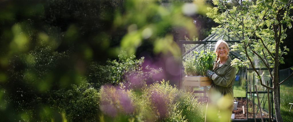 Cover for Homepage, women gardening in lush garden with hints of purple from Summit Orthopedics. 