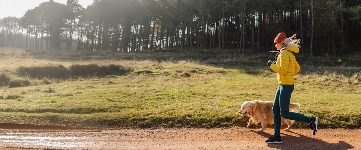 Women and dog running in fall