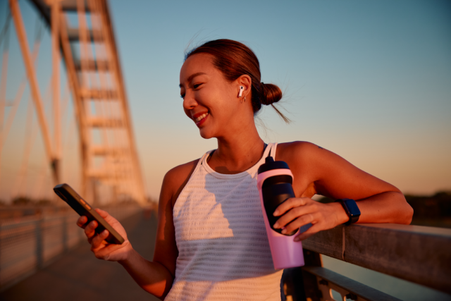 A women enjoying a break at golden hour while running.